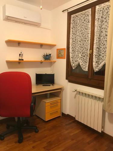 an office with a desk and a red chair and a window at B&B IL VIALETTO in Orio al Serio
