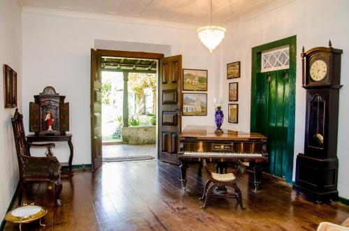 Habitación con escritorio y reloj de abuelo en Pousada da Marquesa en Paraty
