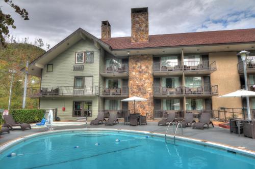 a hotel with a swimming pool in front of a building at River Edge Inn in Gatlinburg