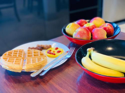 une table recouverte de gaufres et de fruits et 2 bols de nourriture dans l'établissement Ramada Limited 100 Mile House, à One Hundred Mile House