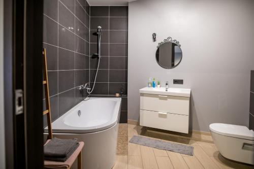 La salle de bains est pourvue d'une baignoire, de toilettes et d'un lavabo. dans l'établissement Spacious and sunny apartment in Birstonas center, à Birštonas