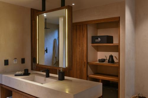 a bathroom with a sink and a mirror at Casa Agape Hotel Tulum & Vegan Restaurant with Beach Club Access in Tulum