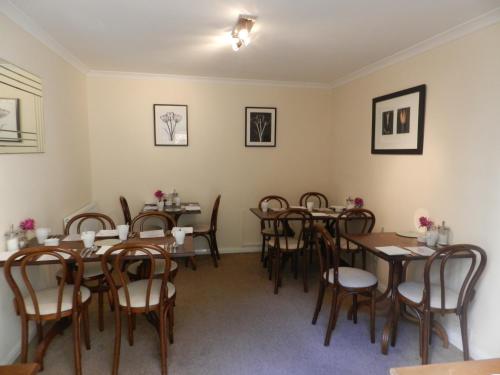 a dining room with wooden tables and chairs at Senlac Guesthouse in Hastings