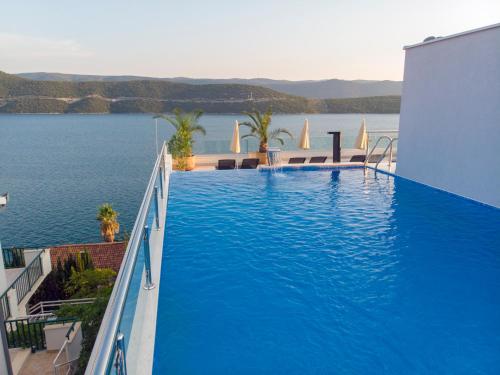 een zwembad met uitzicht op het water bij Hotel Villa Nova in Neum