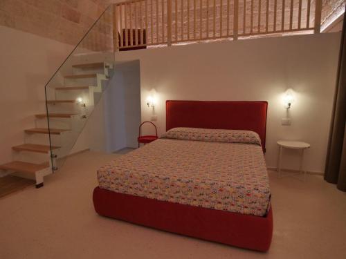 een slaapkamer met een rood bed en een trap bij MandorleOlio in Polignano a Mare