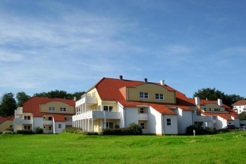 a row of houses with red roof at A plus Ferienpark Usedom in Ostseebad Koserow