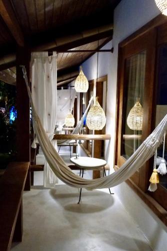 a hammock in a room with a table and chairs at Pousada Tartaruga Boutique Hotel in Pipa