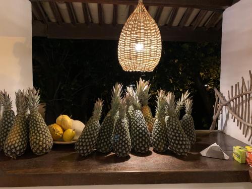 a bunch of pineapples on a table with a light at Pousada Tartaruga Boutique Hotel in Pipa