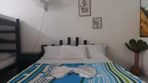 a bedroom with a bed with two clothes on it at Hostal Recuerdos del Tayrona in El Zaino