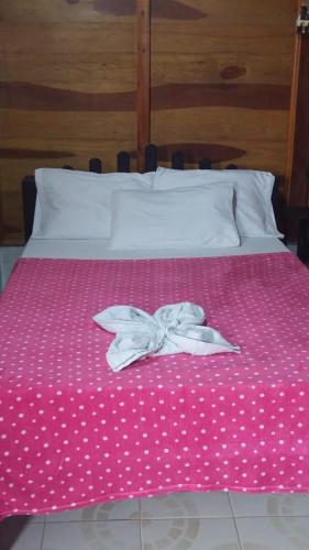 a pink bed with white polka dots on it at Hostal Recuerdos del Tayrona in El Zaino