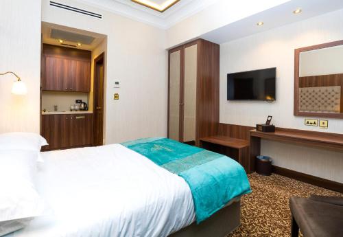 Un pat sau paturi într-o cameră la Kensington Prime Hotel