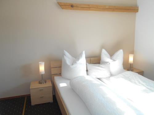 um quarto com 2 camas com lençóis brancos e 2 candeeiros em Gästehaus Kling em Rettenbach