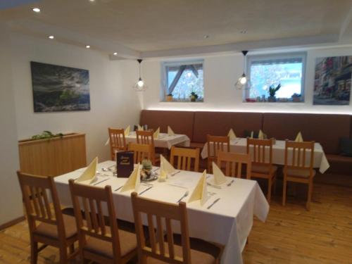 uma sala de jantar com mesas e cadeiras num restaurante em Gästehaus Kling em Rettenbach