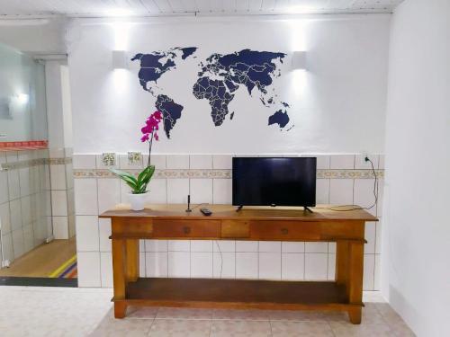 un escritorio con TV y un mapa mundial en la pared en Hotel Digital Ponte Aerea - Aeroporto de Congonhas, en São Paulo