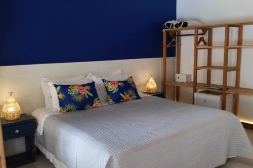 a bedroom with a white bed and a blue wall at Pousada Tartaruga Boutique Hotel in Pipa