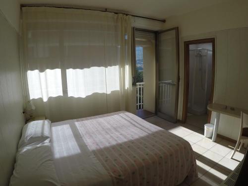 a bedroom with a bed and a large window at Albergo Nyers in Perugia