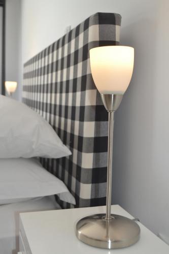a lamp sitting on a table next to a bed at Comfort Stay Athens Airport Hotel - FREE shuttle from and to the airport in Spáta