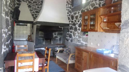 a kitchen with a table and a fireplace at Casa da Alícia in Feiteira