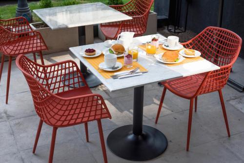 a white table with red chairs and food on it at The PopCity Hotel in Santiago