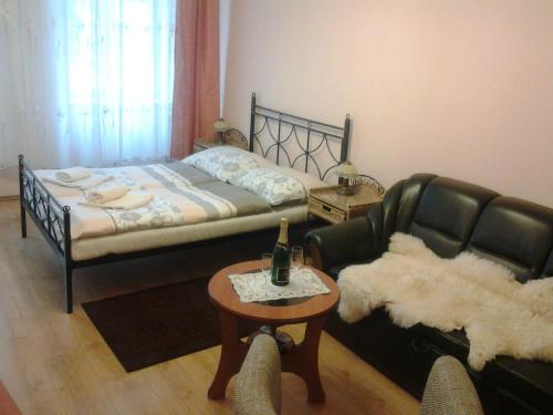 カルロヴィ・ヴァリにあるU Tří jehňátekのベッドルーム1室(ベッド1台、テーブル、ソファ付)