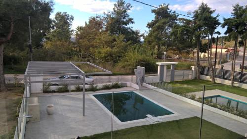 托羅尼的住宿－Divine Luxury Apartments，庭院中带游泳池的房子