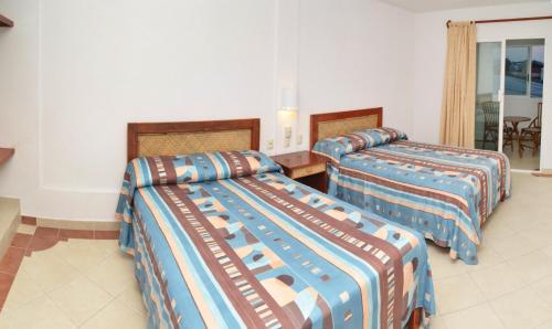 a hotel room with two beds in a room at Hotel Suites Ixtapa Plaza in Ixtapa