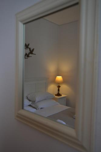 a reflection of a bed in a mirror with a lamp at Comfort Stay Athens Airport Hotel - FREE shuttle from and to the airport in Spáta