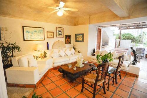 a living room with a white couch and a table at Hotel Suites Ixtapa Plaza in Ixtapa