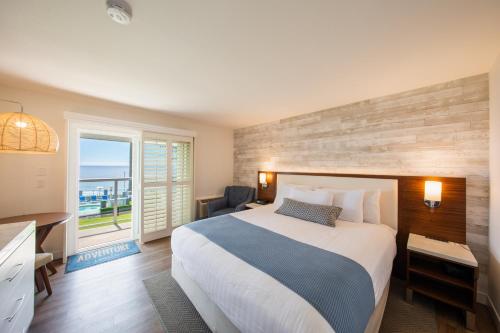 a bedroom with a large bed and a balcony at SeaCrest Oceanfront Hotel in Pismo Beach
