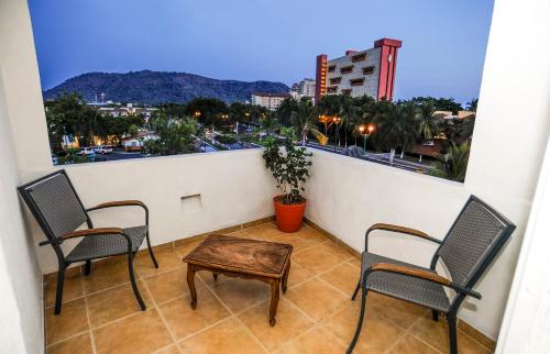 two chairs and a table on a balcony with a view at Hotel Suites Ixtapa Plaza in Ixtapa
