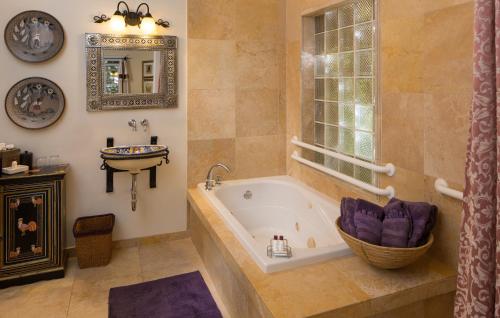 
a bath tub sitting next to a window in a bathroom at Casa Blanca Inn and Suites in Farmington
