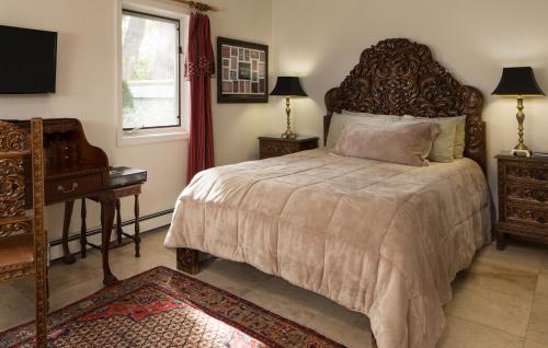 a bedroom with a bed and a desk and a piano at Casa Blanca Inn and Suites in Farmington