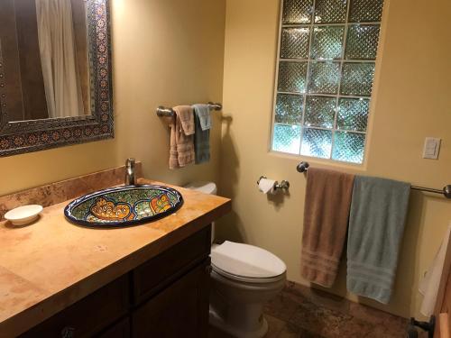 a bathroom with a sink and a toilet and towels at Casa Blanca Inn and Suites in Farmington