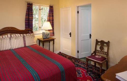 a bedroom with a bed and a chair and a window at Casa Blanca Inn and Suites in Farmington