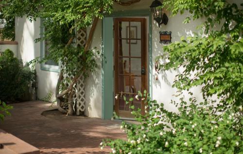 a front door of a white house with a green door at Casa Blanca Inn and Suites in Farmington