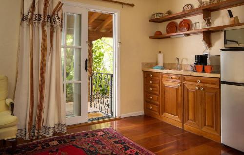 a kitchen with a refrigerator and a sliding glass door at Casa Blanca Inn and Suites in Farmington