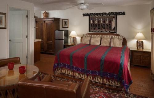 a bedroom with a bed and a table and a couch at Casa Blanca Inn and Suites in Farmington
