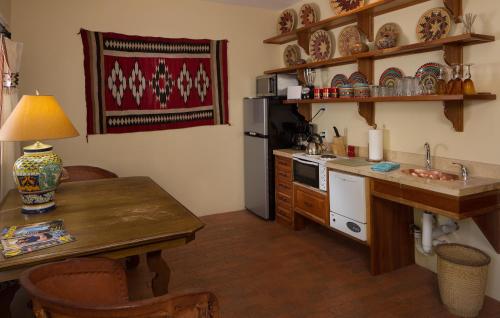 a kitchen with a table and a sink and a refrigerator at Casa Blanca Inn and Suites in Farmington