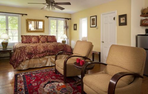 a bedroom with a bed and two chairs in it at Casa Blanca Inn and Suites in Farmington