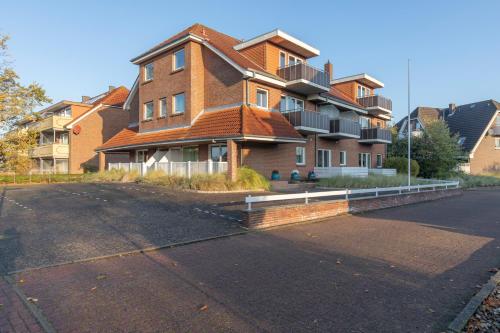 a large brick building with a roof on a street at Appartementhaus Gouverneur-Maxse Büsum in Büsum