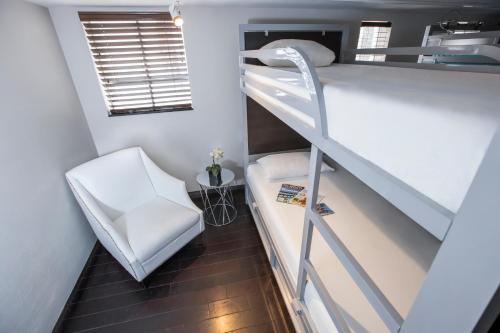 邁阿密海灘的住宿－珀斯南海灘酒店，小房间设有双层床和椅子