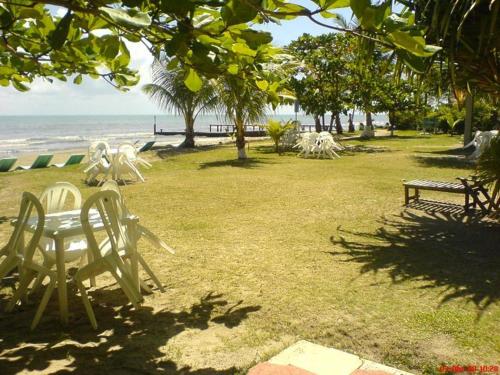 park z krzesłami i stołem na plaży w obiekcie Hotel Salvador Gaviota w mieście Lívingston