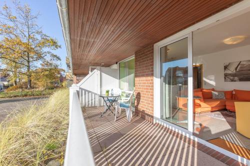 an outdoor deck with a couch and a table at Appartementhaus Gouverneur-Maxse Büsum in Büsum
