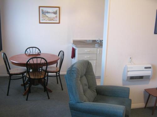a living room with a table and a chair and a table and a chair at Blue Dolphin Motel in Timaru