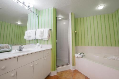 a bathroom with green stripes and a tub and sink at Cape Canaveral Beach Resort in Cape Canaveral