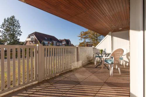 a porch with a fence and a table and chairs at Appartementhaus Gouverneur-Maxse Büsum in Büsum