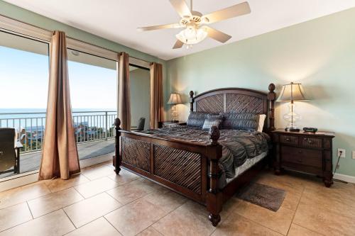 a bedroom with a bed with a fan and a balcony at Sterling Shores III in Destin