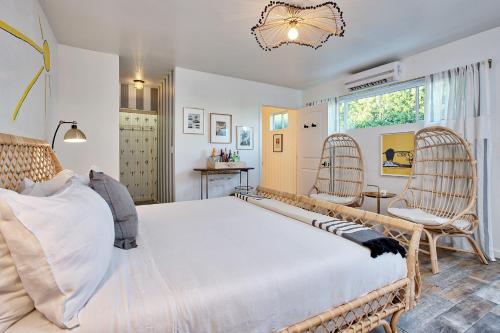 a bedroom with a large bed and two chairs at Dive Palm Springs in Palm Springs
