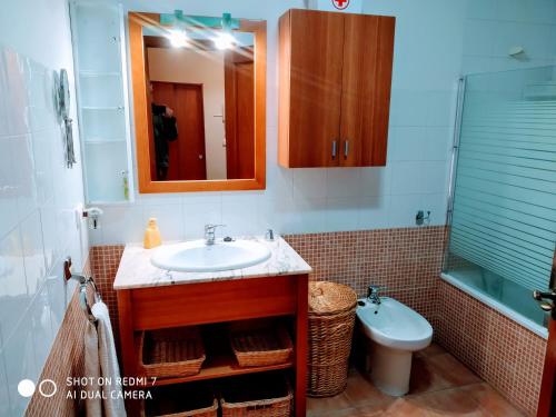 bagno con lavandino, servizi igienici e specchio di Ático19 a Mora de Rubielos