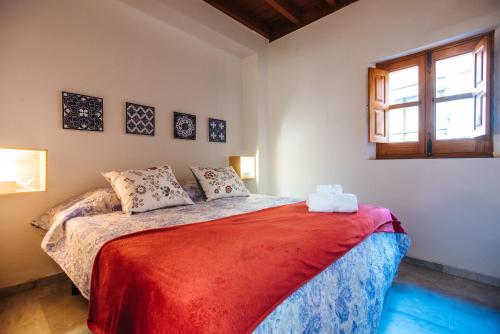 セビリアにあるDivi Apartaments Centro Sevillaのベッドルーム1室(赤い毛布付きのベッド1台付)
